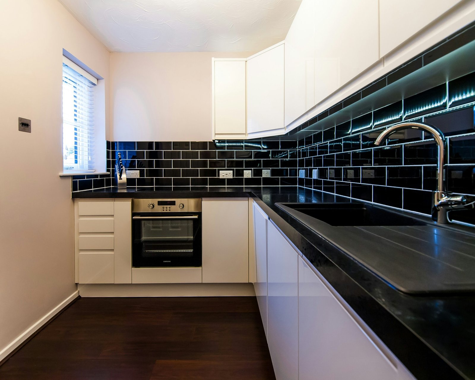 a kitchen with a black counter top and white cabinets